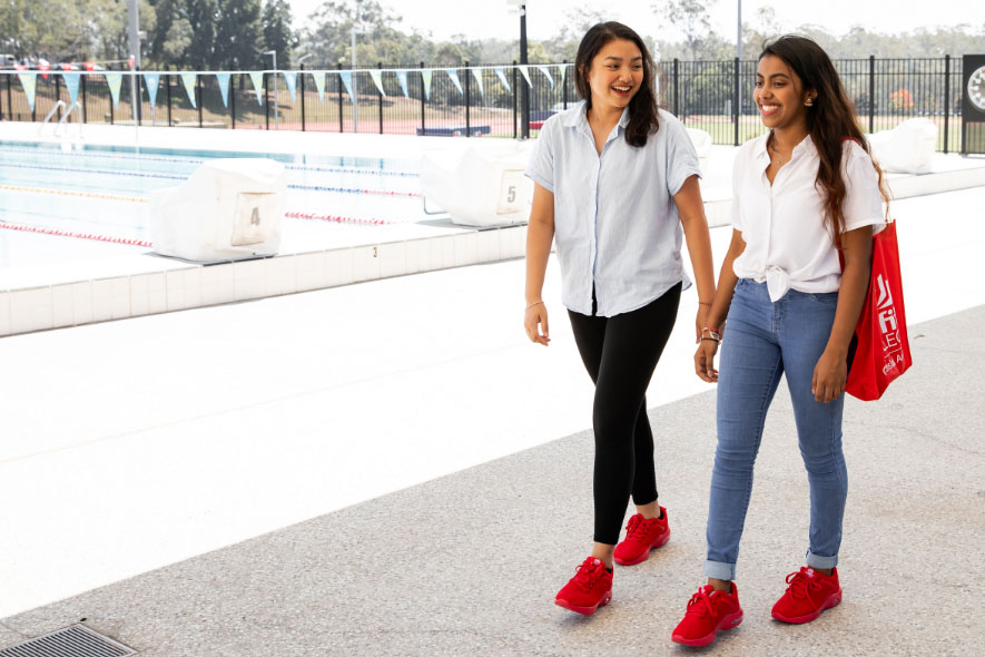 Female students walking sport pool facilities